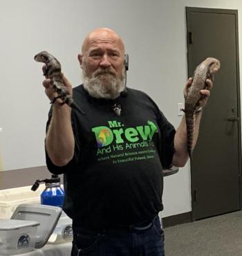 Mr. Drew compares a healthy blue-tongued skink (right) with one that has a permanent spine curvature from metabolic bone disease. The latter did not receive proper care after being purchased from a pet store. ISABELLE CURTIS/Boothbay Register