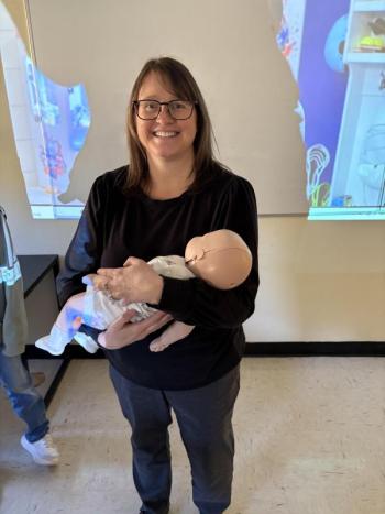 Jennifer Harris, of First Point Training, holds a training infant used in the American Red Cross Babysitter Training. Courtesy of Raye Leonard