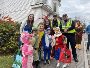 A group stops for a photo with Boothbay Harbor police officers near Grover's Hardware during the 2025 parade. Bethany Schmidt photo