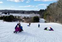 Sledding action on the big hill at Salt Bay Farm during a Coastal Rivers sledding party.  Courtesy photo