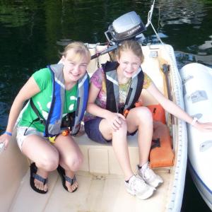 Allie, left, and Cate Withee sit in the boat the sisters used to win the Windjammer Days Boating Treasure Hunt. Courtesy of Suzanne Withee