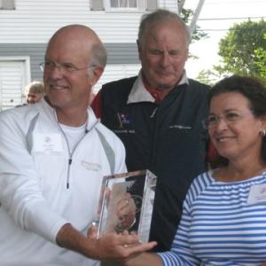 2012 Lobster Run winner Ken Coburn (owner and skipper of "Apparition" with wife Ginny Colburn, right) receives the first place award from Principal Race Officer Robin Wallace, center.