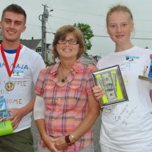 The first and second place winners of Wannawaf's eighth annual waffle-eating contest Anton and Maja Ekman with the recipient of the fundraising event Pam Creamer, center, who suffers from chronic Lyme disease. Below, Waffle Girl Anya Arsenault shares information about one of the contest prizes – a slushy maker. LISA KRISTOFF/Boothbay Register The first and second place winners of Wannawaf's eighth annual waffle-eating contest Anton and Maja Ekman with the recipient of the fundraising event Pam Creamer, center, who suffers from chronic Lyme disease. LISA KRISTOFF/Boothbay Register