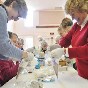 Jane Lunt, left, and Penny Thumith work together to construct cocoa cones