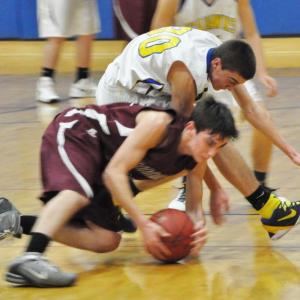 Evan Hepburn, center, battles with a Monmouth Mustang for a loose ball. 