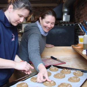 Treats Kitchen Manager Heidi Eastman of Edgecomb, left, and owner Stacy Linehan of Westport Island add crystallized ginger to oven-bound ginger snaps at the Wiscasset business. The store will make heart-shaped snaps for Valentine's Day. SUSAN JOHNS/Wiscasset Newspaper