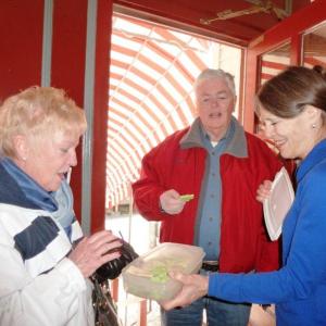 Nancy Gilchrist, right, offers a St. Patrick’s Day cookie to Joyce Tomecko of Rhode Island while John Appleton looks on. KATRINA CLARK/Boothbay Register