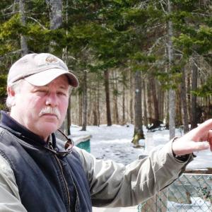 Mike Warren points out spots on the ice off the Penny Lake Bridge where his new 8-week old puppy chased wood ducks last week. KATRINA CLARK/Boothbay Register