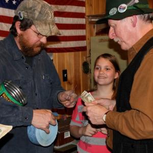 Treasurer Keith Royal sells a raffle ticket to Earl Leavitt as Jackie Steinmetz eagerly waits her turn. The monthly $1 raffle drew a long line. SUE MELLO/Boothbay Register
