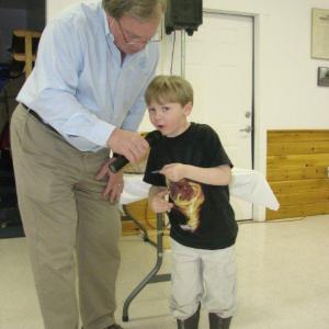 Five-year-old Mason Paquette helps Bill Bailey announce some of the raffle ticket numbers drawn at the Bowl Supper. LISA KRISTOFF/Boothbay Register