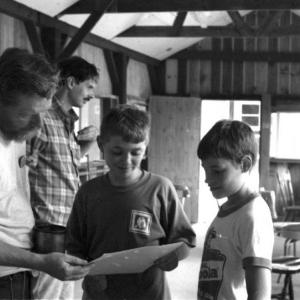 July, 1991: Scouts Eric Schmidt and Gearry Judkins seem happy with a freshly shot target during merit badge work. Instructors Earl Leavitt, foreground, and Carl Schmidt were among several certified members available for BSA and Hunter Safety programs. Courtesy of Lucy Schmidt
