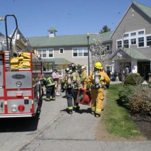 Firefighters carry a fan into the Gregory Wing entrance at St. Andrews Village during Tuesday morning's fire. KEVIN BURNHAM/Boothbay Register Firefighters carry a fan into the Gregory Wing entrance at St. Andrews Village during Tuesday morning's fire. KEVIN BURNHAM/Boothbay Register