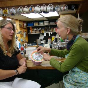 Teresa Simpson, left, talks with Alna Store co-owner Amy Preston, as Preston adds to a donation canister to help cover the stray dog’s medical costs. SUSAN JOHNS/Wiscassest Newspaper