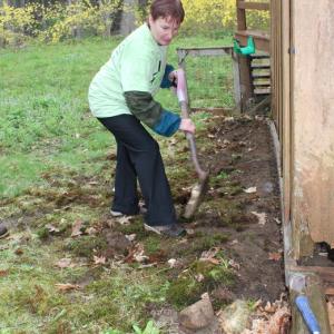  Lorri HIggins clears along a house's edge to prepare for new siding on King Phillips Trail. SUE MELLO/Boothbay Register
