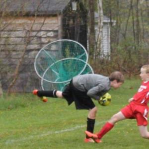 Midcoast striker Will Shafer charges after the ball during the second half of play at Clifford Playground. Shaffer scored on a breakaway in the opening seconds of the match. Below: Simon Spear shows perfect kicking form at midfield. SUE MELLO/Boothbay Register Midcoast striker Will Shafer charges after the ball during the second half of play at Clifford Playground. Shaffer scored on a breakaway in the opening seconds of the match. SUE MELLO/Boothbay Register