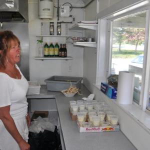 Bet Finocchiaro serves up some fried fish and potatoes May 28 at Bet's Famous Fish Fry in Boothbay. Finocchiaro has been selling just fried fish and potatoes for the last 20 years and said her secret isn't in the sauce but in hard work. BEN BULKELEY/Boothbay Register