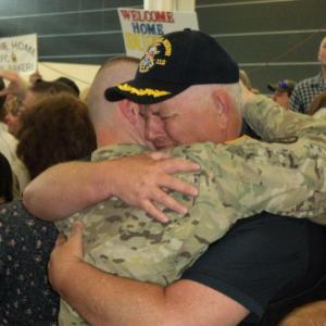 Peter Greenleaf hugs his son, Pvt. Nick Greenleaf, upon his return to Maine June 15. Below: The Greenleaf and Leighton families hold signs welcoming their soldiers home from Afghanistan; Pvt. Mason Leighton talks with his father, Micheal Leighton, and family friend, Patrick Higgins. Courtesy of Isaac Luken Peter Greenleaf hugs his son, Pvt. Nick Greenleaf, upon his return to Maine June 15. Courtesy of Isaac Luken