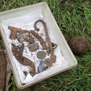 A small sample of the artifacts dug up from the ground in Pemaquid. Among other things, pictured are a musket flint, a lice comb, a coin, a fish spear and a swivel gun cannon ball to the right. BEN BULKELEY/Boothbay Register