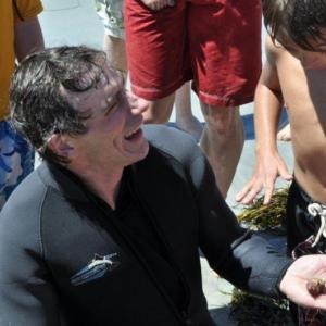 A hermit crab rests on Brian Boone's hand while onlookers get a better look at the bounty the diver pulled from the water. Boone was able to pull out a variety of creatures from a short dive. BEN BULKELEY/Boothbay Register