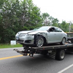 A Lincoln Towncar that collided with a dumptruck is towed away from the accident scene. RYAN LEIGHTON/Boothbay Register