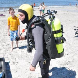 Geared up and ready to dive: Brian Boone, right, stands with almost all 130 pounds of his scuba on at Pemaquid Beach. BEN BULKELEY/Boothbay Register
