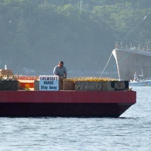 Pyrotechnic Austin Hills prepares for the Fourth of July fireworks show aboard the barge in Boothbay Harbor.  GARY DOW/ Boothbay Register