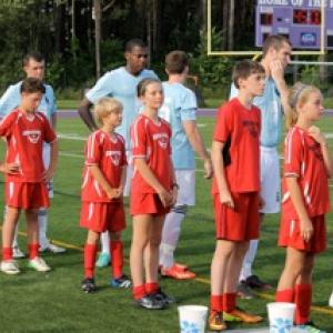 Midcoast United players escort Portland Phoenix onto the pitch at their July 6 match again the Western Massachusetts Pioneers. Midcoast United players from the left: Maddox Tillas, Simon Spear, Jack Duncan, Ella Spear, Timmy Chappelle, Malaika Pasch, and Bayly Gaughan.