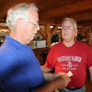Dwight, left, and Duane Lewis look at the photos of themselves during their school days at the June 29 party at Robinson's Wharf. KEVIN BURNHAM/Boothbay Register
