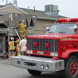 Boothbay firefighters inspect the malfunctioning air conditioner behind the gas station. RYAN LEIGHTON/ Boothbay Register