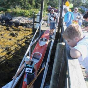 A young boy watches as kayaks are carried down to the dock on August 10. SUE MELLO/Boothbay Register