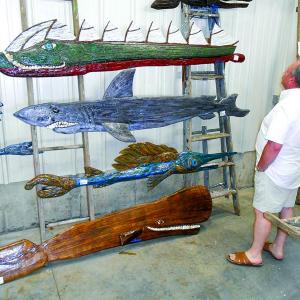 Dan Biron of Lee, N.H. admires the folk art of Souhport's Mike Lewis at Lincoln Art Festival's Arts & Yachts show held at the Boothbay Region Boatyard. GARY DOW/Boothbay Register