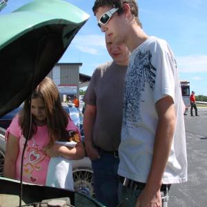 Alannah Bryer, left, age 9, father Darrell Bryer and Alannah's brother Ian Bryer, 15, all of Wiscasset, look over a 1948 Crosley at an antique auto display during the Wings event. SUSAN JOHNS/Wiscasset Newspaper