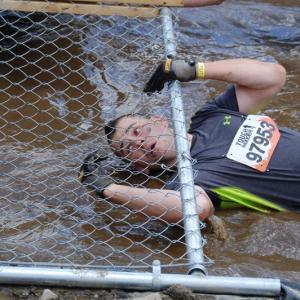 Jared Mitkus enters the mud pool/chain link fence crossing. Courtesy of John Mitkus
