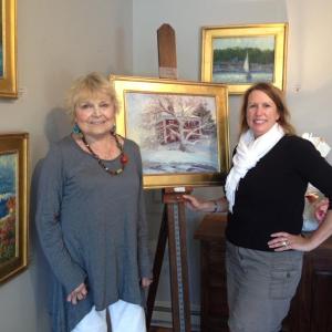 Kathleen Billis, left, and COCO VIVO Fine Art owner Mary Phelps. The Billis work on the easel, “A Northern Farm” in Waldoboro is just one of the new works in a series called, “Feels Like Home” running through August 31. LISA KRISTOFF/Boothbay Register