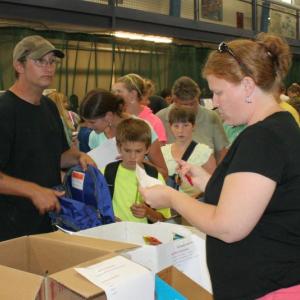 Volunteer Heather Lorrain checks a list of school supplies for Derek Averill’s son. KEVIN BURNHAM/Boothbay Register