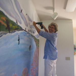 Artist Jane Dahmen hangs her contribution to the DRA's 40th anniversary art show, “Visions of the River,” which runs August 10-17 in Damariscotta. Courtesy of Damariscotta River Association