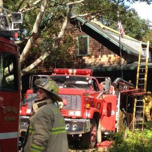 Boothbay Fire Chief Dick Spofford is called in for backup to a Bay Street chimney fire while crews scale the roof tops to clean the chimney. RYAN LEIGHTON/ Boothbay Register