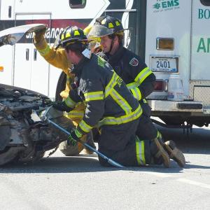 Boothbay Fire Dept. personnel work to open the hood of the Mercury. GARY DOW/Boothbay Register