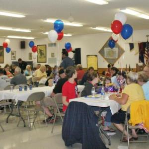 The Hometown Heroes crowd of about 100 people sits down to enjoy the meal of hamburgers and hot dogs. KEVIN BURNHAM/Boothbay Register