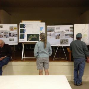 Southport residents look over maps and photos of the property and beach at the town meeting. NICOLE LYONS/Boothbay Register