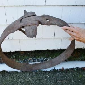 A photo of the mastband that was found on Damariscove. The tightening mechanism is at top; part of the spike that was driven into the mast is on the left. The hole shows where the other spike was. KEVIN BURNHAM/Boothbay Register