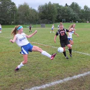 Sinead Miller scrambles to keep the ball inbounds against a Lisbon defender. Miller scored two goals in the home opener on September 16. RYAN LEIGHTON/Boothbay Register