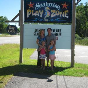 Kristen Gosselin, her husband John, and two daughters in front of their new Sea Horse Playzone sign. Courtesy of Kristen Gosselin