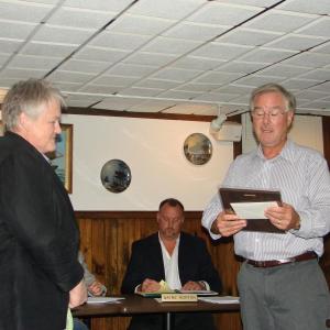 Marge Kilkelly, left, of Dresden looks on as Maine Yankee spokesman Eric Howes reads a plaque honoring Kilkelly's service with the Maine Yankee Community Advisory Panel. Seated nearby is Maine Yankee's chief nuclear officer Wayne Norton. SUSAN JOHNS/Wiscasset Newspaper