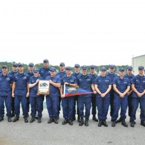 THE COAST Guard Station was recently awarded with the Sumner I. Kimball Award, which is given to the station that keeps exemplary care of boat material equipment, boat and personal protective equipment, has superlative crew proficiency and compliance with training requirements and readiness. Here, the crew stands near the harbor with the plaque and pennant they received. BEN BULKELEY/Boothbay Register