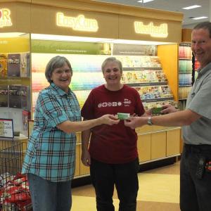 Ames Supply owner Wayne Averill presents gift certificates to winners Sharon Rogers, left, and Patricia Smith.