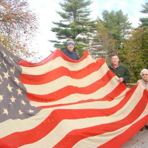 Wiscasset author Phil DiVece, left, Lincoln County Historical Association President Ed Kavanagh and longtime Wiscasset resident Bee King, now of East Boothbay, hold up an 1896 flag King’s grandmother sewed. King donated it to the historical association on October 28. SUSAN JOHNS/Wiscasset Newspaper Wiscasset author Phil DiVece, left, Lincoln County Historical Association President Ed Kavanagh and longtime Wiscasset resident Bee King, now of East Boothbay, hold up an 1896 flag King’s grandmother sewed. King donated it to the historical association on October 28. SUSAN JOHNS/Wiscasset Newspaper