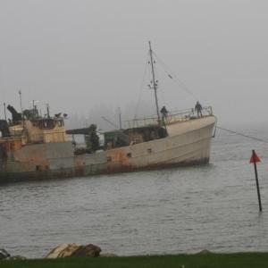 Lobsterman Bill Hallinan tows the Westward back out to its mooring off Signal Point after it had broken loose sometime Thursday morning. KEVIN BURNHAM/Boothbay Register