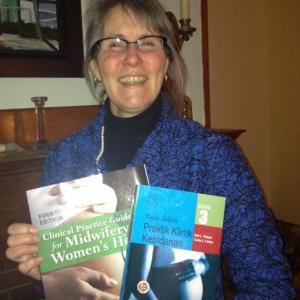 Nell Tharpe, MS, RN, CNM, CRNFA, with copies of the U.S. and Indonesian versions of “Clinical Practice Guidelines for Midwifery & Women's Health,” co-written with Cindy L.Farley. LISA KRISTOFF/Boothbay Register