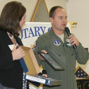 Lt. Col. Tyler Blake of the Air National Guard presents a special flag and photograph to club president Jennifer Page Osman. KEVIN BURNHAM/Boothbay Register